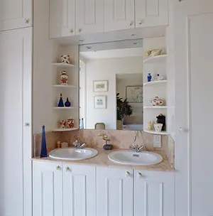 Shelving Prints: Shelves on either side of mirror above double basins in white vanity unit with storage cupboards in traditional
