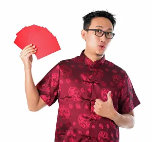 Verrotten Prints: Shocked Asian Chinese man holding many red packets Shocked Asian Chinese man holding many red packets / ang pow for