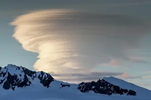 Cold Temperature Prints: Shorefast ice and snow covered mountains with a lenticular cloud build up in Wilhamena Bay
