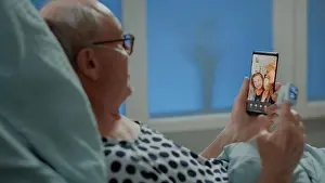 Oxygen Prints: Sick elder patient talking on videocall with family in hospital ward