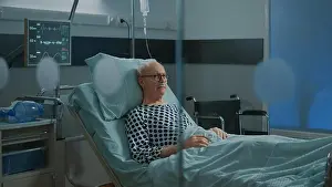 Heavy Prints: Sick old man staying in hospital ward bed with oximeter