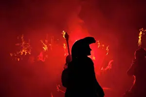 Arts Culture And Entertainment Prints: Silhouette of pirate with burning torch from Southover Bonfire Society lit by red flares on United Grand Procession
