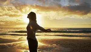 Feeling Prints: Silhouette of a woman on the beach at sunset outside