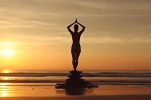 Balance Prints: Silhouette of woman doing yoga by sunrise at the beach. Generative AI