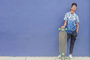 Denim Prints: Skateboard teen against blue wall
