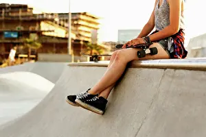 Evening Light Prints: Skateboarder taking a break at a skatepark during golden hour