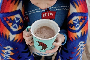 Chocolate Prints: sky view of a boy wrapped in a blanket holding a hot chocolate outside
