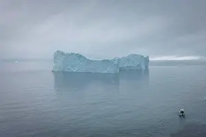 Global Prints: small boat sailing in front of extreme icebergs from aerial view