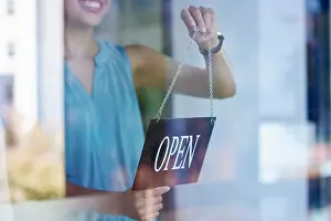 Opening Prints: Small business, woman and entrepreneur with open sign excited at professional shop window entrance