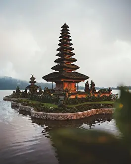 Calm Prints: Small complex of prayer pagoda with green garden around built in water on shore against fog