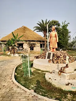 Status Prints: A small statue of Swami Vivekananda with a village hut next to it at a village in Joygopalpur
