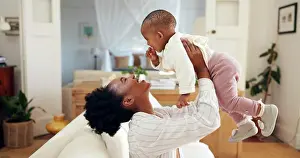 Lifting Prints: Smile, mother and play with baby at house for airplane