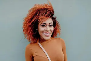 Front Views Prints: Smiling beautiful woman against gray wall