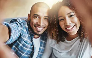 Purchase Prints: Smiling couple taking selfies as home owners