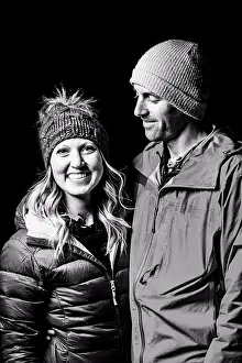 Positive Emotion Prints: Smiling couple in warm clothing standing against black background