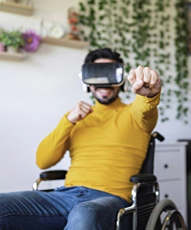 Disability Prints: Smiling disable man wearing virtual reality headset punching at home