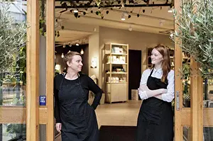 Entrances Prints: Smiling female owners standing at doorway of store