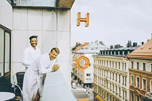 Balcony Prints: Smiling gay couple enjoying in hotel balcony