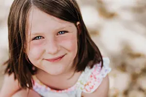 Facial Expression Prints: Smiling girl with bright blue eyes and freckles looks at camera