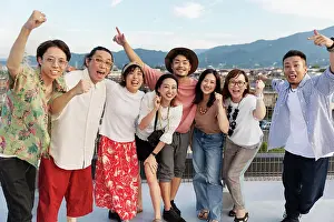 Japanese Ethnicity Prints: Smiling group of young Japanese men and women standing on a rooftop in an urban setting