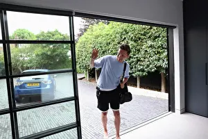 Smiling man walking insidegym with shoulder bag and waving