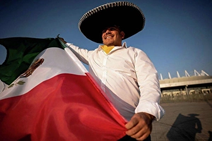 Distinct Prints: Smiling man wearing sombrero holding Mexican flag on sunny day