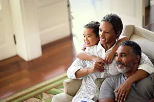 50 To 55 Years Prints: Smiling mature couple enjoying time with their granddaughter inside their home