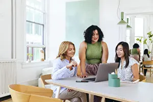 Multiracial Group Prints: Smiling multiracial colleagues during meeting in creative office