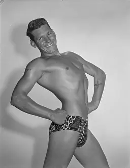 Bodybuilder Prints: Smiling Tattooed Muscular Male in Leopard Skin Trunks c.1953