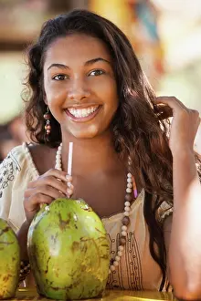 Gleeful Prints: Smiling teenage girl drinking from coconut
