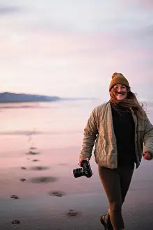 Laugh Prints: Smiling Young Female Photographer on Oregon beach at sunrise