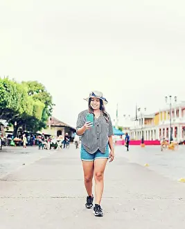 Networks Prints: Smiling young tourist in hat walking with cell phone on the street