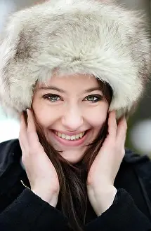 Winter Clothes Prints: Smiling young woman wearing a fur hat, portrait