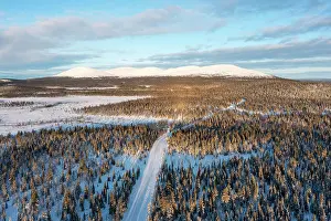 Finland Prints: Snow-covered country road, behind it the Pallastunturi, Muonio, Lapland, Finland