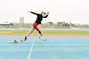 Runner Prints: Sportswoman with prosthetic leg running near the starting blocks