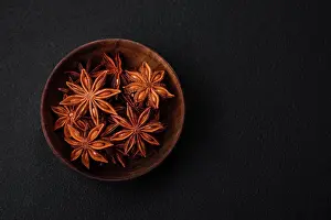 Dekoration Prints: Star shaped spice star anise in a wooden round bowl Star shaped spice star anise in a wooden round bowl on a dark