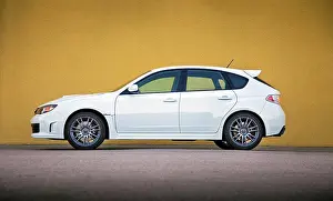 Asphalt Prints: Static profile view of a white 2012 Subaru Impreza WRX STI parked in front of a plain yellow wall