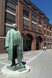 Exterior Photograph Prints: Statue of Adam Opel in front of the old portal of the Opel plant in Ruesselsheim