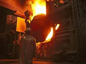 Manual Worker Prints: Steelmaking plant converter being filled with crude iron