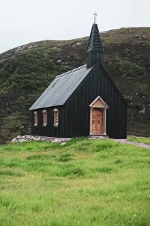 Kindness Prints: striking black wood church sits on wild hillside in remote scotland