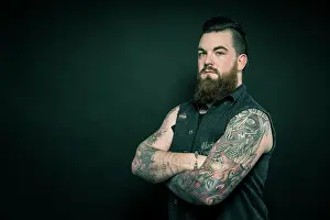 Tattoo Prints: Studio portrait of a bearded man with tattooed arms