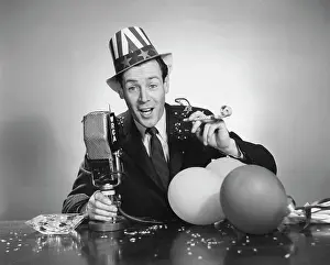 Shirt And Tie Prints: Studio portrait of man with microphone and party blower