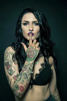 Tattoo Prints: Studio portrait of a young woman with tattooed arms