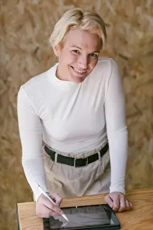 Smart Prints: Stylish blond businesswoman smiling looking at camera while bending over table