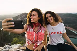 Expressive Prints: Stylish women taking selfie on breathtaking landscape