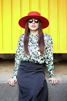 Skirt Prints: Stylish young hispanic woman looking at camera on a yellow wall