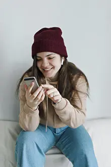 Facial Expression Prints: Stylish young woman smiling, using phone, listening to music
