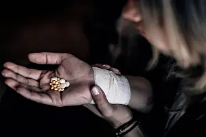 Disorder Prints: Suicidal woman holding number of pills in hand