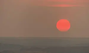 Coast Prints: The sun gets low in the sky approaching the horizon at dusk