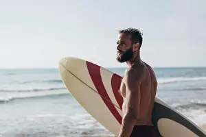 Waves Prints: Surfer holding his surfboard on the beach - Hipster man standing on the beach